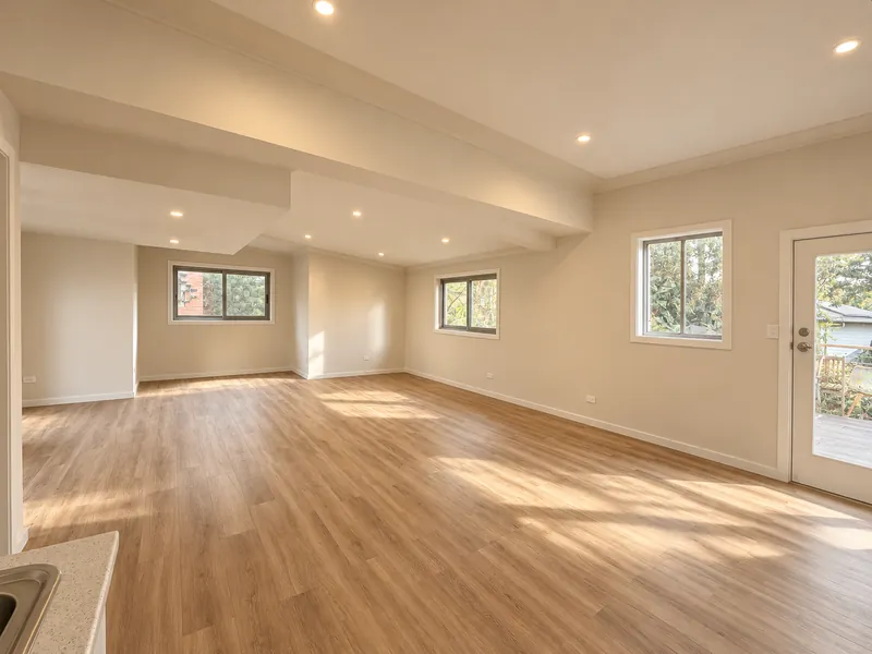 Open-plan converted living space with warm timber floors and garden doors