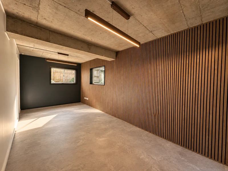 Contemporary converted room with timber wall panels and exposed beams